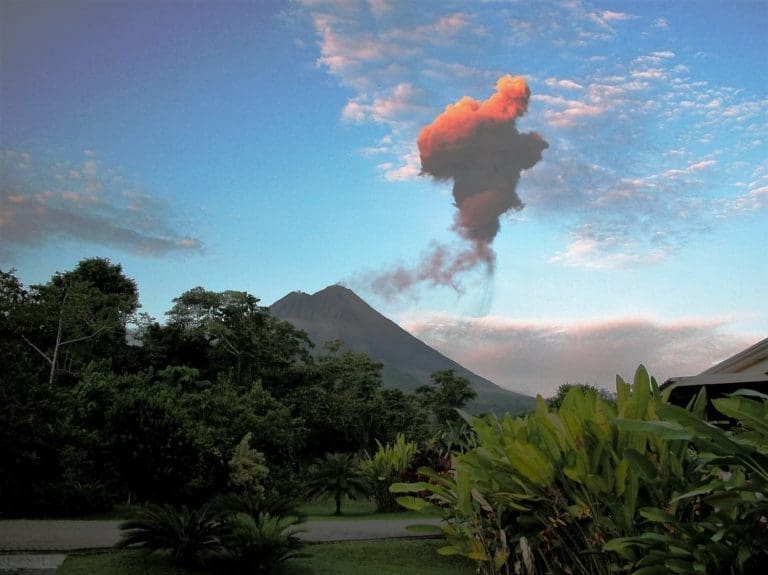 A plume of pink ash erupting from Arenal Volcano at dawn, Costa Rica