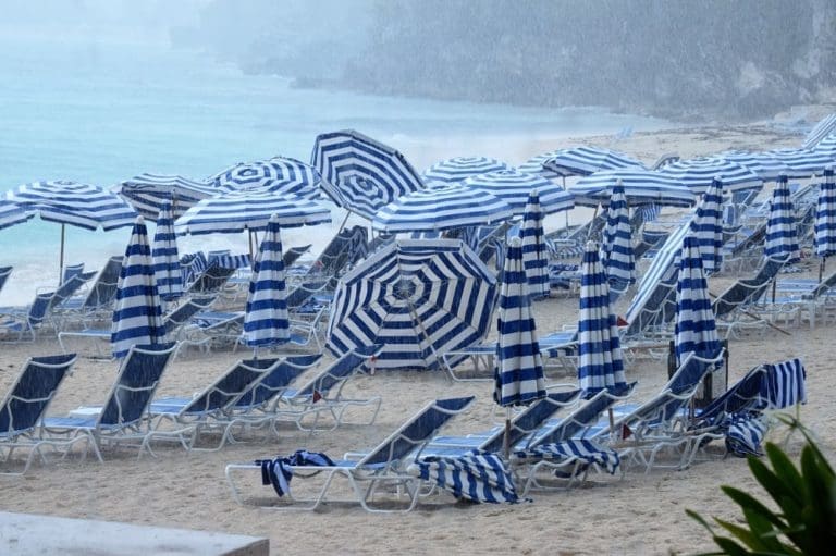 Striped beach umbrellas blown over and inside out by the storm