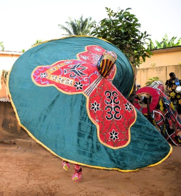 Two vibrant whirling Egungun masquerade dancers in Benin during a ritual fortune telling Voodoo ceremony